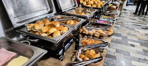 A buffet with various food items including rolls and pastries. - Hotel Benfica (Aparecida)