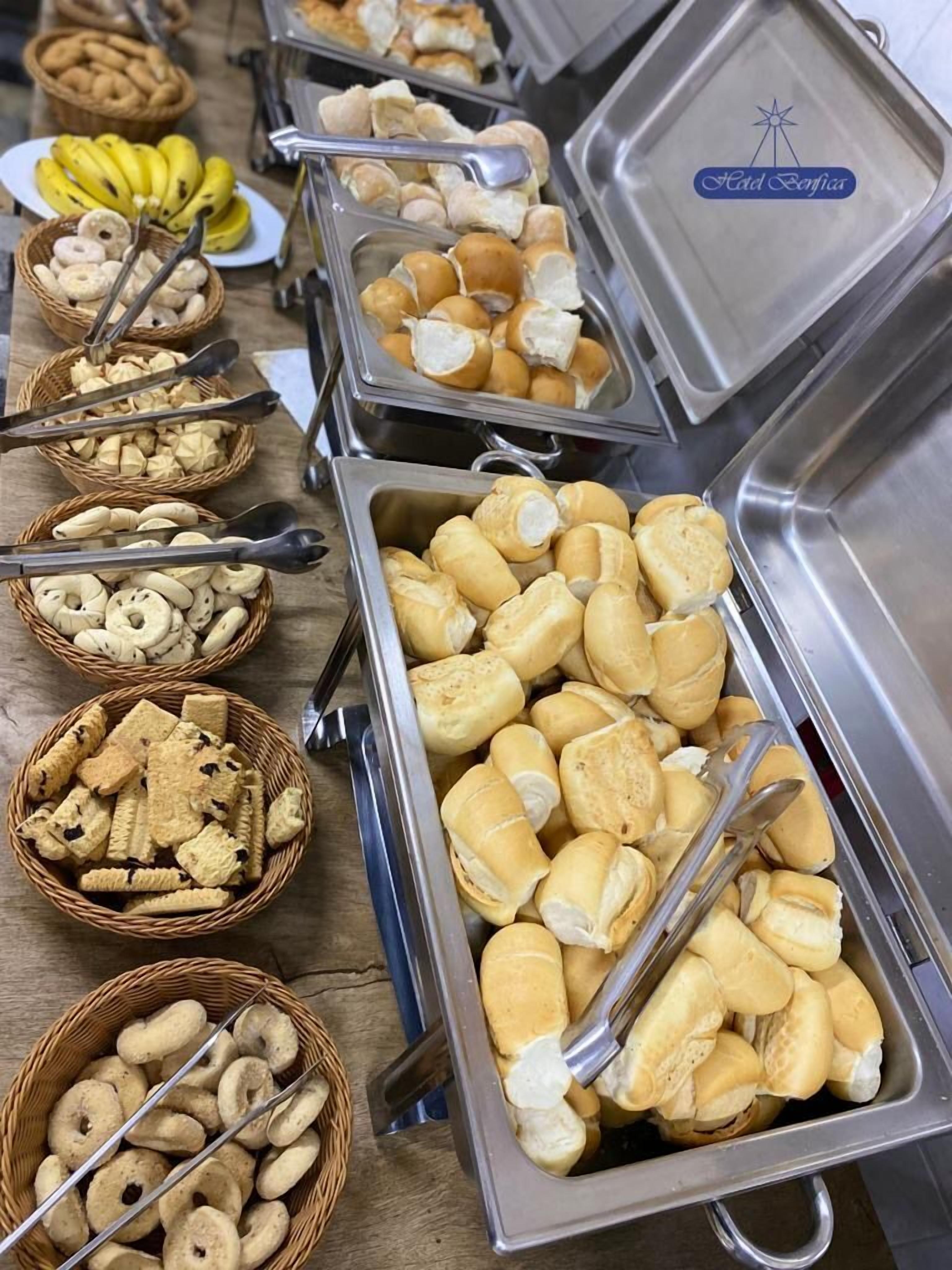Un bufé con diversos alimentos, incluyendo bollos de pan, galletas y plátanos.