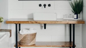 Un baño con un lavamanos blanco, un espejo grande y un mueble de tocador de madera.