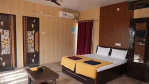 A hotel room with a bed, a small table, a ceiling fan, and an air conditioning unit. - Bimal Farm Home Stay (Koroli)