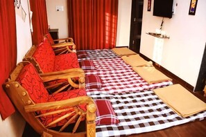 A room with a checkered floor mat, wooden furniture, and red curtains.