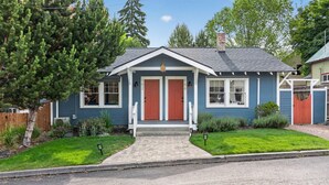 A two-story house with a front porch, a chimney, and a well-maintained lawn. - Oak Millhouse - Beautifully restored home in Downtown Old Bend (Bend)