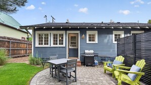 A house with a patio, a grill, and outdoor seating.