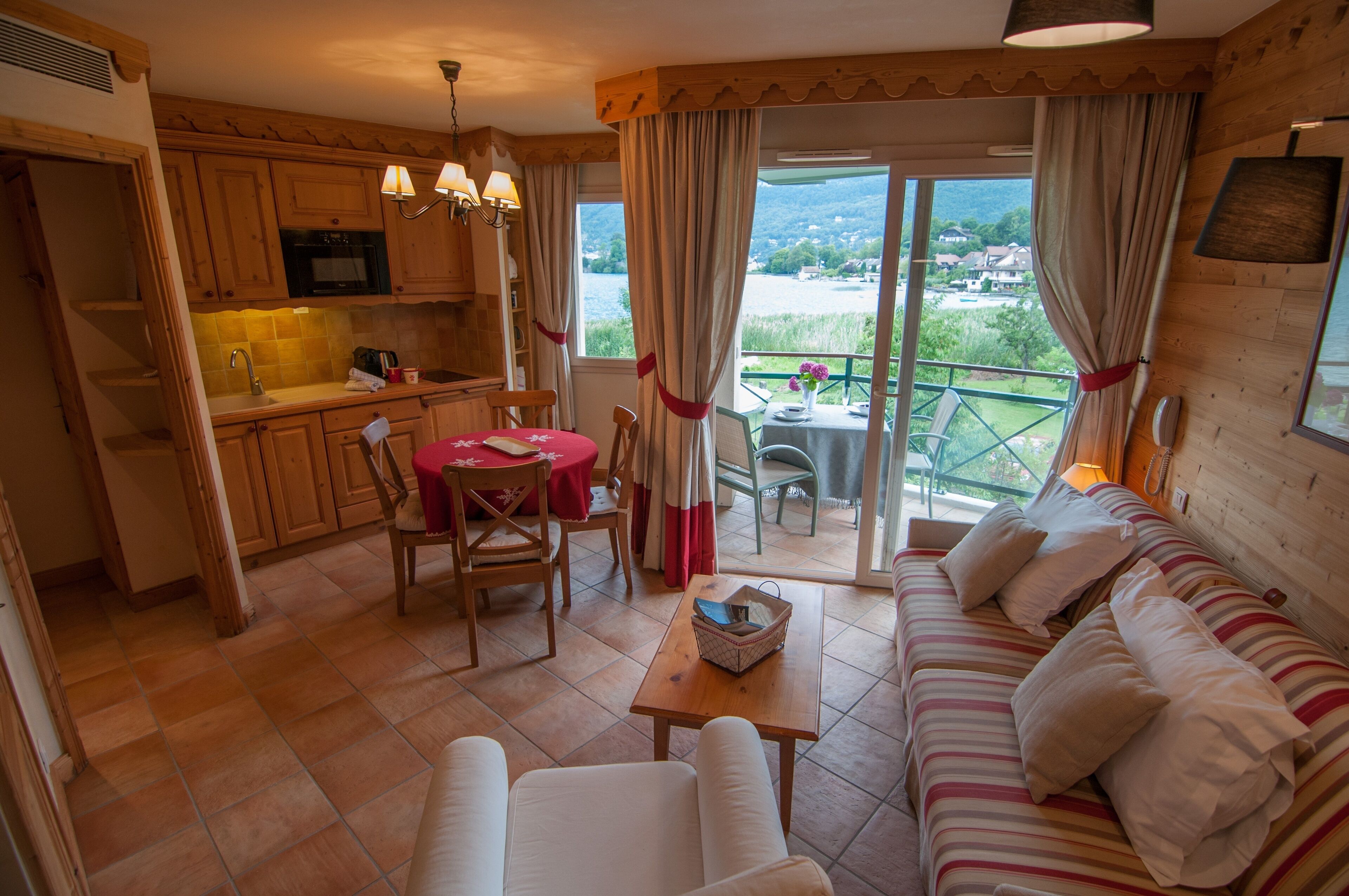 A cozy room with a dining area, a sofa, and a kitchen.