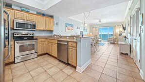 A modern kitchen with stainless steel appliances, wooden cabinets, and a large island.