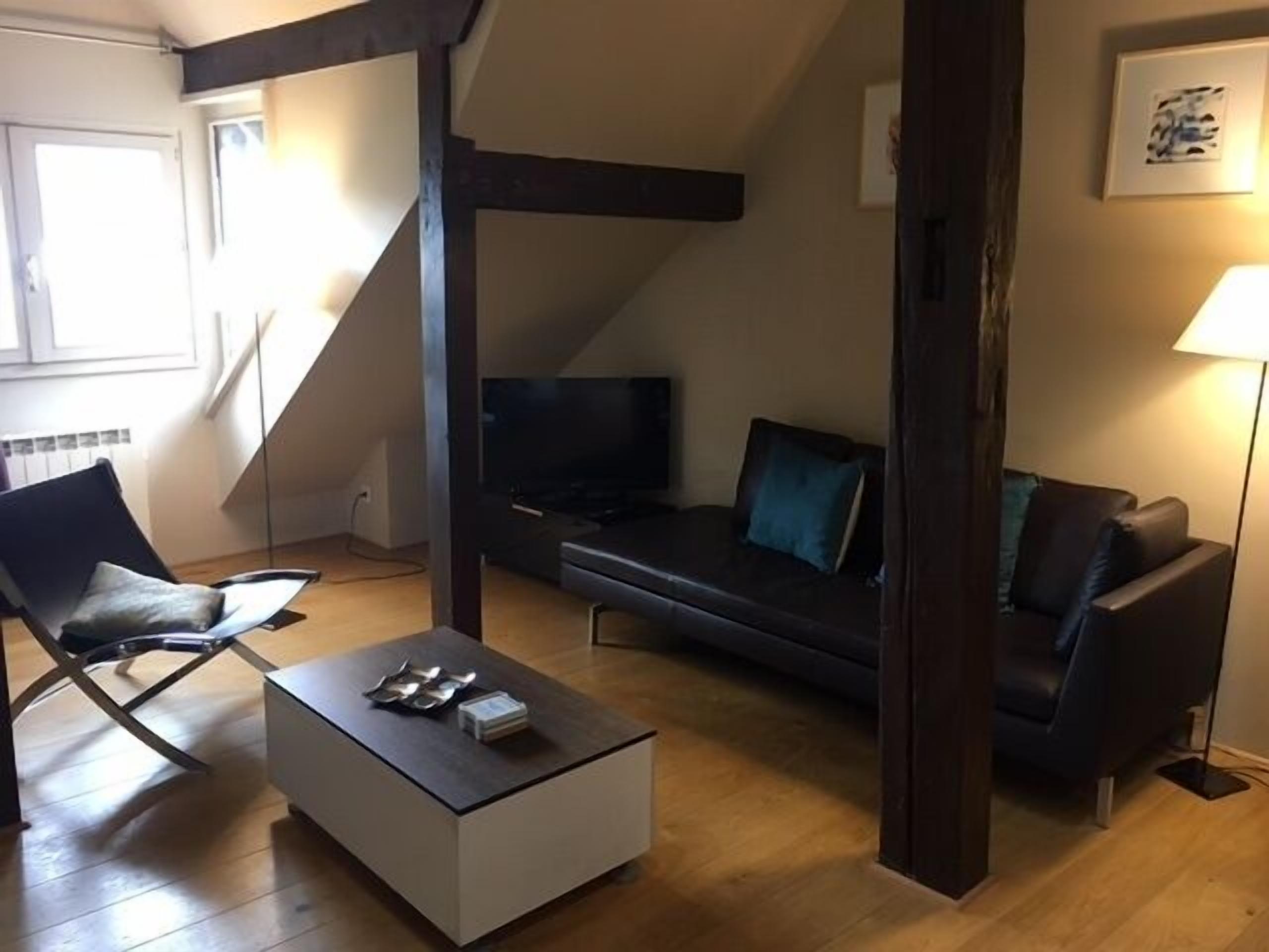 A modern living room with a sofa, a coffee table, and a TV.