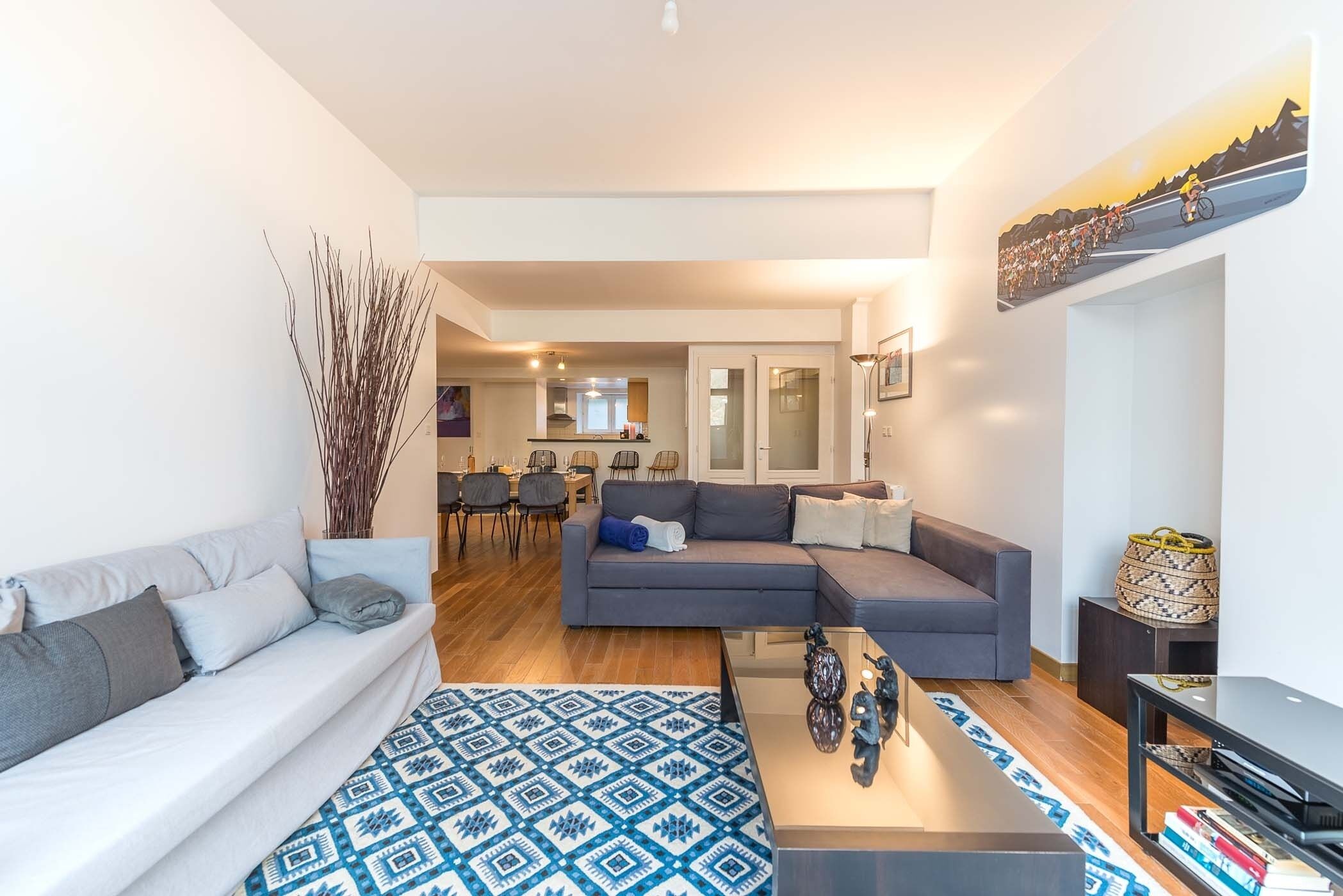 A modern living room with a sofa, a patterned rug, and a coffee table.