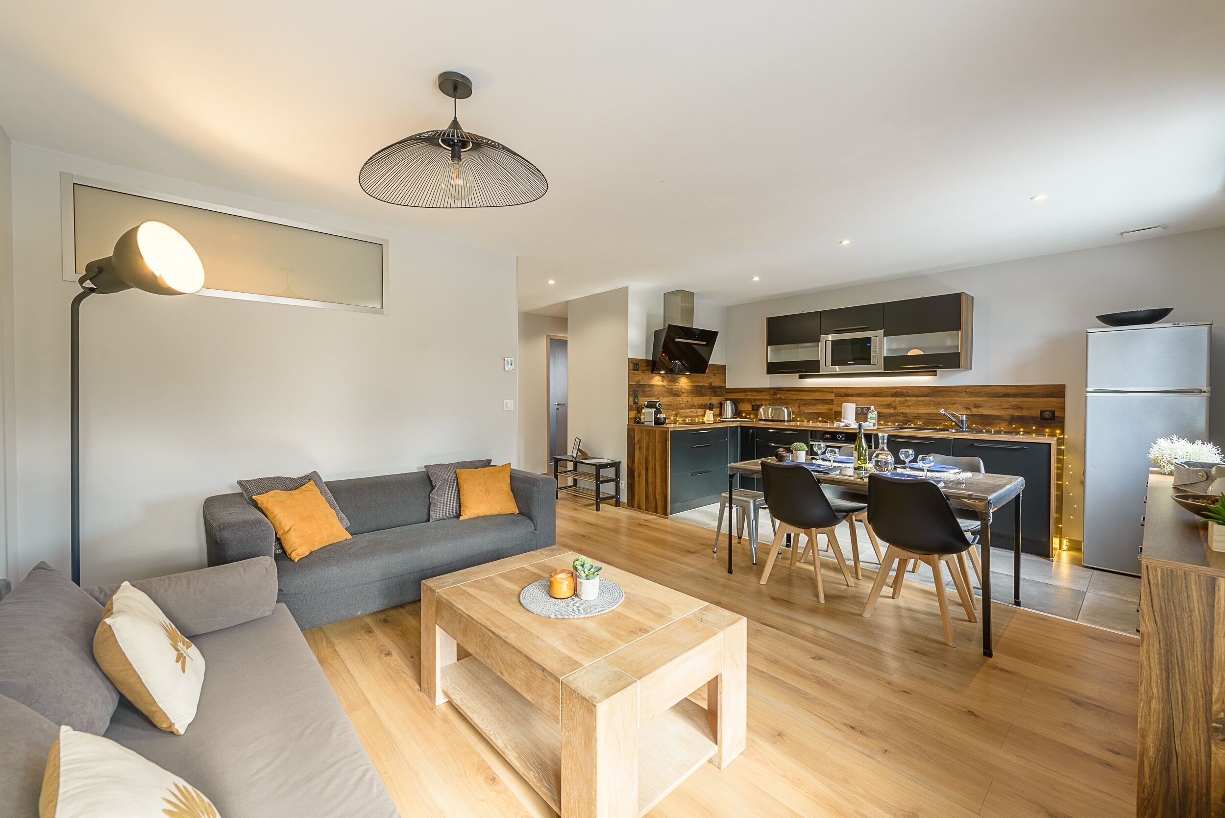 Un salon moderne avec un canapé, une table basse et un coin repas.