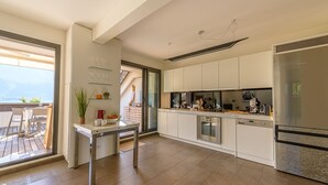 Eine moderne Küche mit weißen Schränken, Edelstahlgeräten und einem Essbereich mit Tisch und Stühlen.
