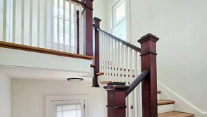A staircase with wooden steps and dark wooden railings, leading to an upper floor. - Bright & Modern Prime Location (Jacksonville)