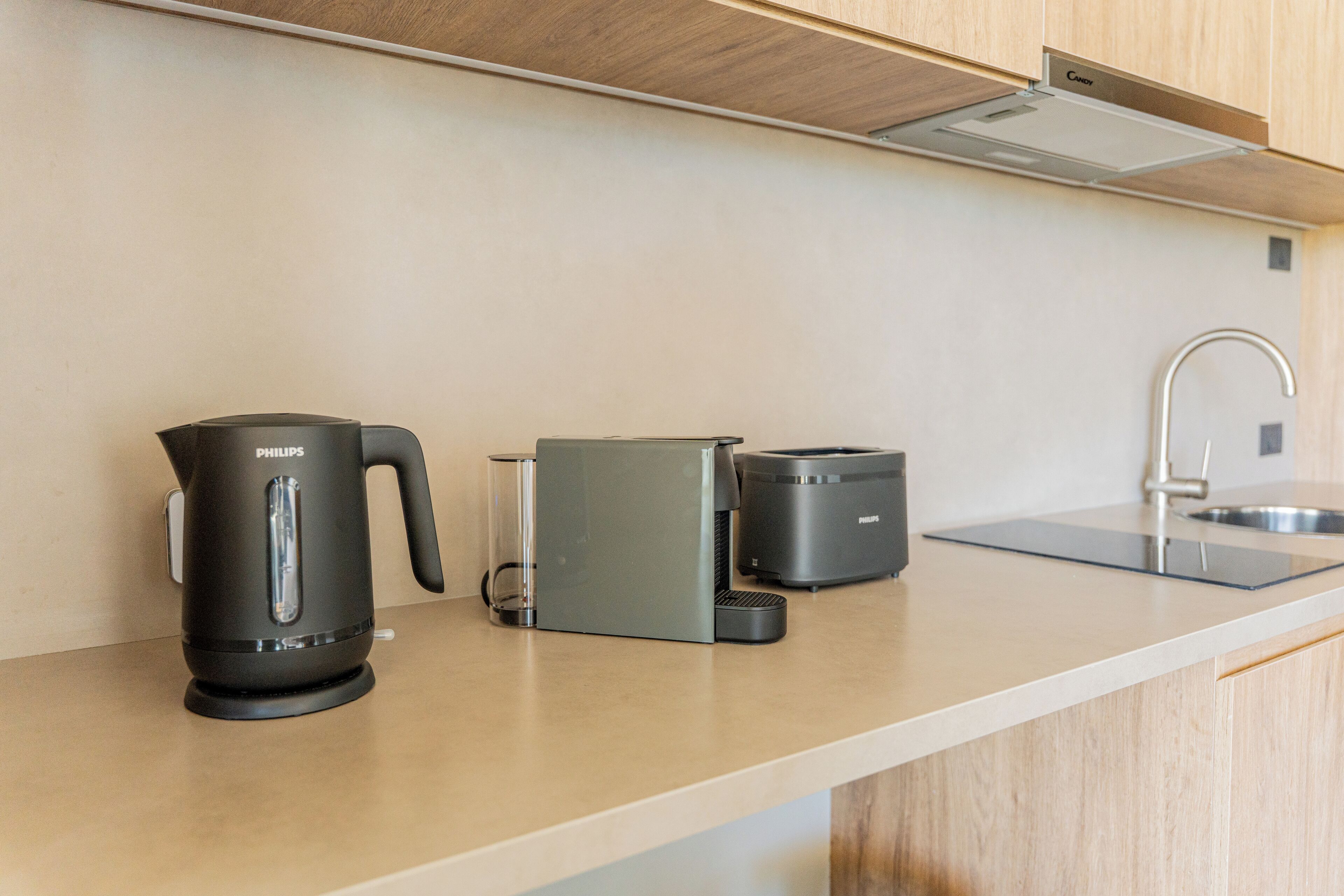 A modern kitchen with a coffee maker, a kettle, and a toaster on the counter.