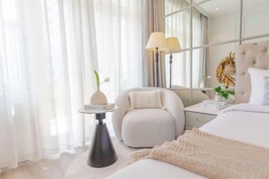 A modern bedroom with a bed, bedside table, lamp, and a decorative wall piece. - Keypad Hotel - Nhân Hòa (Hanoi)