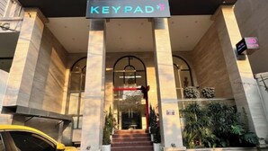 The entrance of a hotel named "KEYPAD" with a modern design, featuring a staircase and potted plants. - Keypad Hotel - Nhân Hòa (Hanoi)