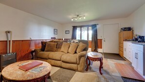 A living room with a sofa, a coffee table, and a fireplace. - Fish & Hike! Home Base for Kachemak Bay Adventures (Homer)
