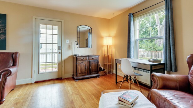 A room with a wooden floor, a desk with a chair, a leather armchair, a cabinet, and a large window with curtains. - Home 2 Mi to Shenandoah Nat'l Park & Skyline Drive (Front Royal)