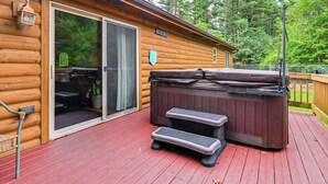 A wooden cabin with a hot tub, outdoor seating, and a deck. - Pet Friendly Cabin w/ Hot Tub: 5 mi to River (Wisconsin Dells)