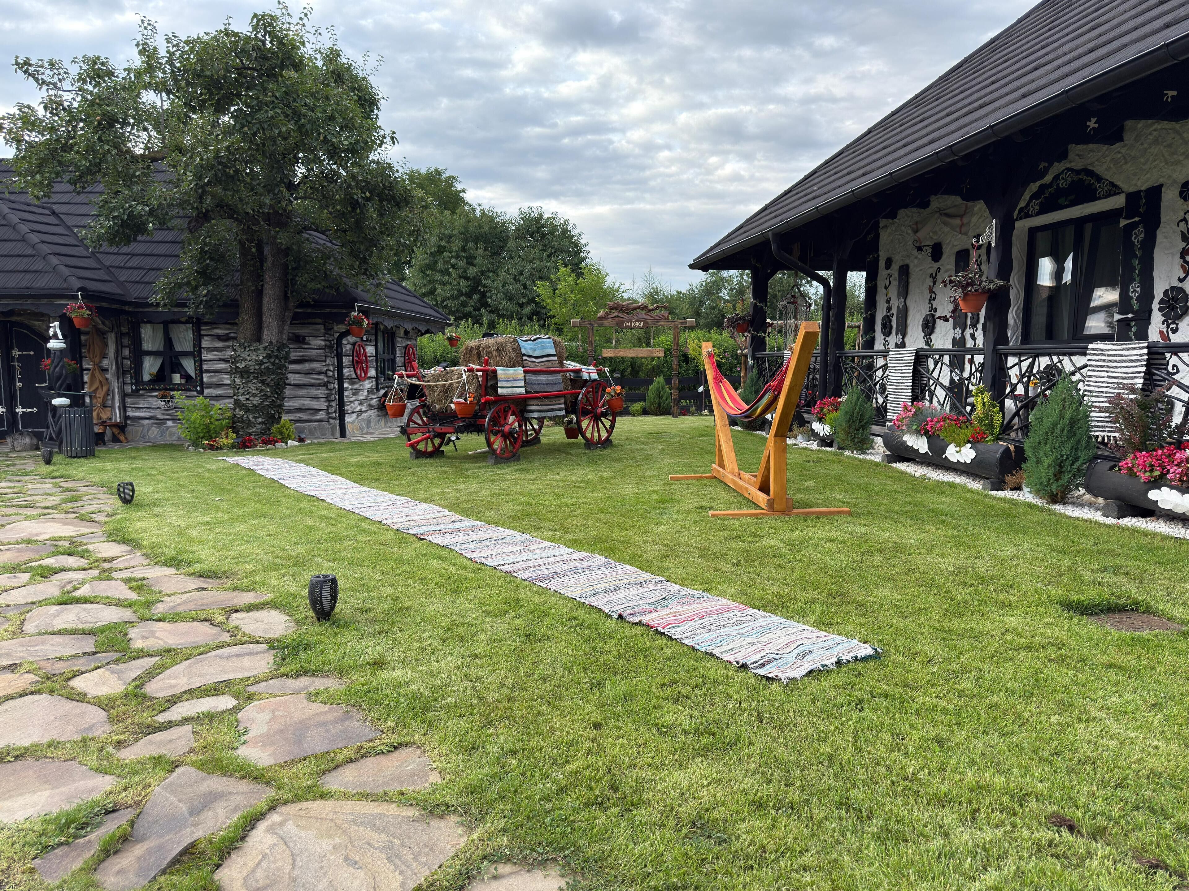 A rustic wooden house with a stone pathway leading to the entrance.