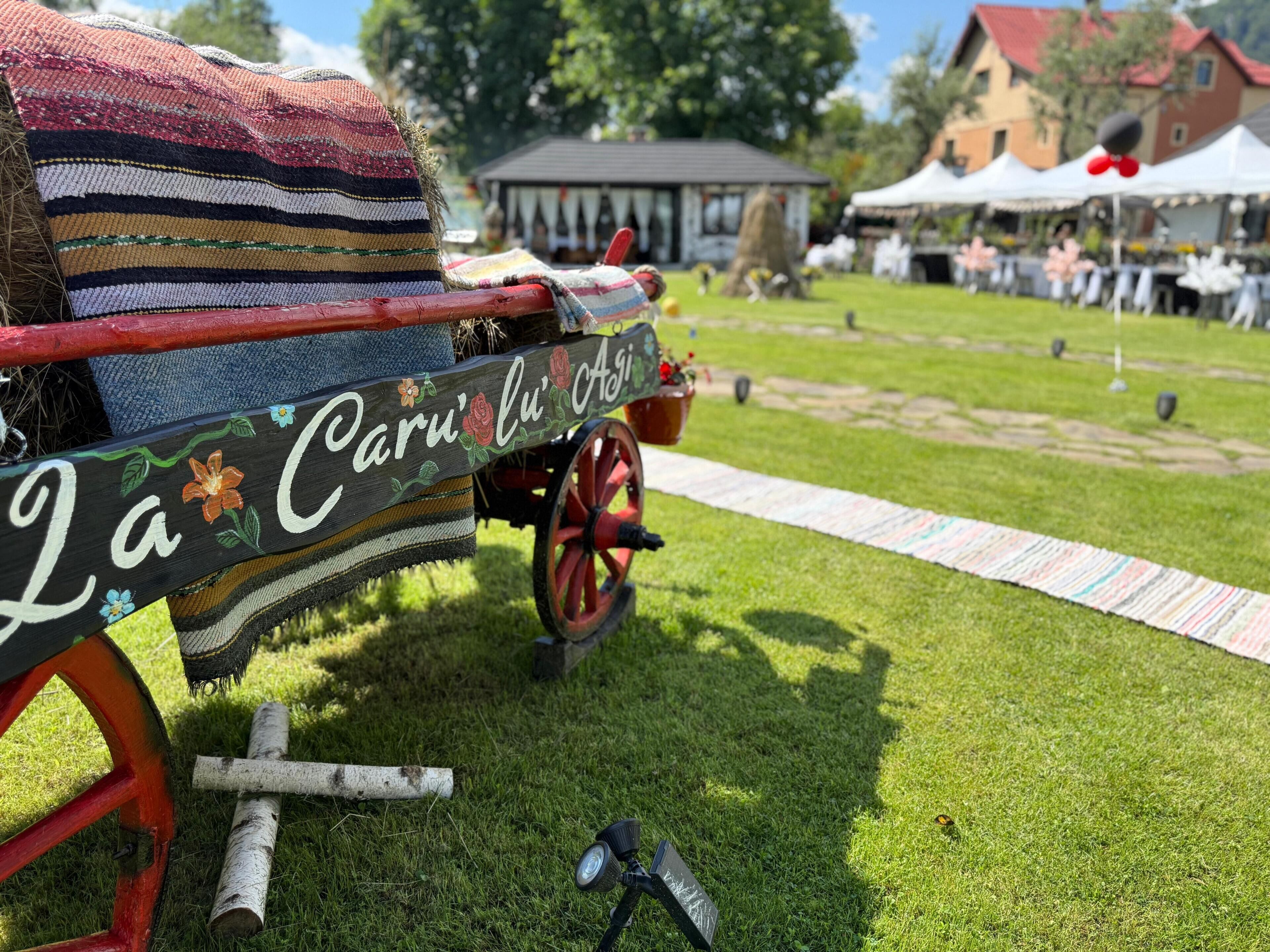 Un carromato rústico con un paño decorativo y un letrero que dice 'La Caru'lu' o' Ais'.