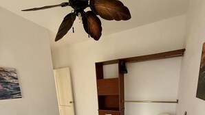 A bedroom with a bed, a ceiling fan, a wardrobe, and a chair. - Traveler SOLO (Playa del Carmen)