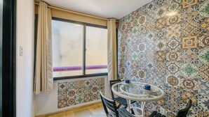 A room with a large window, patterned tiles, and a round table with chairs. - Fully Equipped Apartments Just Steps From Barra Beach and Barra Lighthouse - Csfs (Salvador)