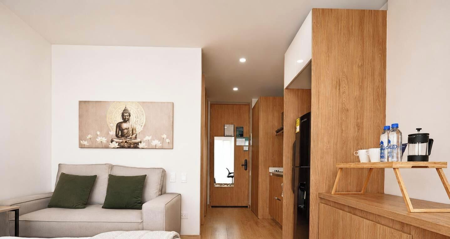 Una sala de estar moderna con un sofá, un cuadro y un mueble de madera con una cafetera.