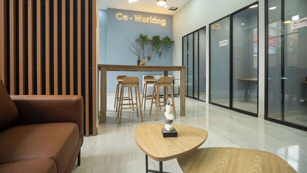 A modern co-working space with a wooden reception desk, comfortable seating, and glass walls. - High Park 94 by Jalo (Bogotá)