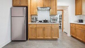 Une cuisine avec des meubles de rangement en bois, un réfrigérateur en acier inoxydable, une cuisinière et un four à micro-ondes.