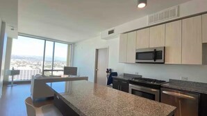 A modern kitchen with granite countertops, stainless steel appliances, and a view of the city. - Ultra Modern 1BD 1BA Flats in heart of LA - true gem (Los Angeles)