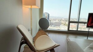 A modern living room with a large window, a floor lamp, a round table, and a sofa. - Ultra Modern 1BD 1BA Flats in heart of LA - true gem (Los Angeles)