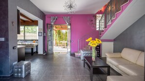 A modern interior with a staircase, a dining area, and a sofa.