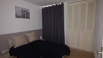 Tabla de planchar con plancha, internet y ropa de cama