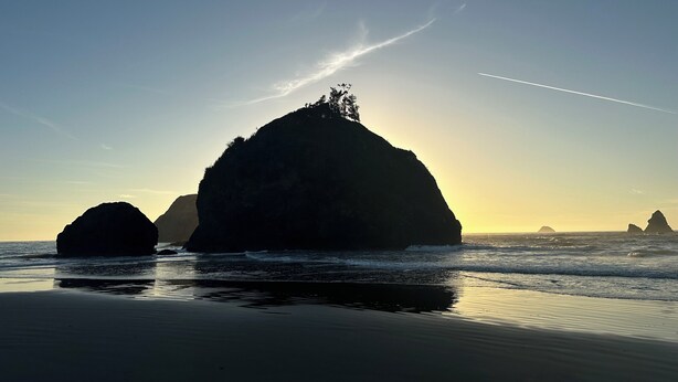A beach with large rock formations and calm waves. - Cozy  Coastal by Beaches & Redwoods (McKinleyville)