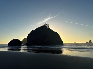 A beach with large rock formations and calm waves.