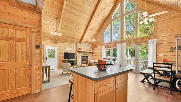 A spacious wooden cabin interior with a kitchen, dining area, and living room. - Log Cabin Luxury Near IU & Lake Monroe (Bloomington)