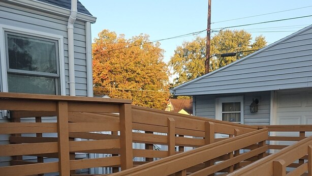 A wooden fence with horizontal slats, a concrete ground, and a house with a grey roof in the background. - Spacious Family Retreat w/ADA Ramp & ADA bathroom (Maumee)