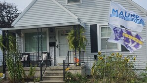 A house with a porch, a flag, and a mailbox. - Spacious Family Retreat w/ADA Ramp & ADA bathroom (Maumee)