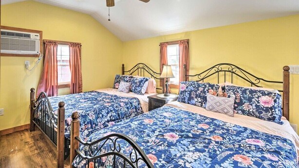 A bedroom with two beds, a ceiling fan, and a window with curtains. - Green Mountain Retreat: Pocono Suites (Pleasant Mount)