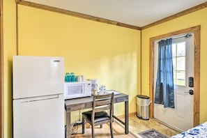 A compact room with a kitchenette, including a refrigerator, microwave, and coffee maker. - Green Mountain Retreat: Pocono Suites (Pleasant Mount)
