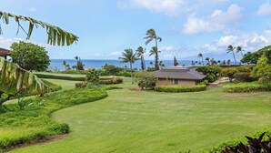 A well-maintained golf course with a clubhouse, lush greenery, and a view of the ocean. - Kaanapali Plantation By Chase N Rainbows (Lahaina)