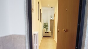Een gang met een marmeren trap die naar een kamer leidt.