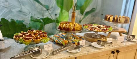 A buffet with various food items and a decorative centerpiece.