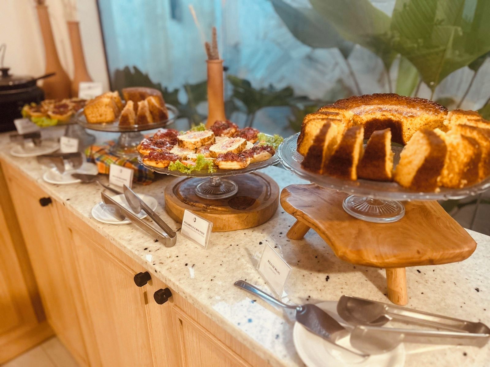 A buffet counter with various food items displayed on wooden stands.