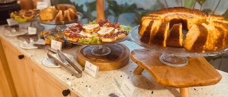 A buffet counter with various food items displayed on wooden stands.