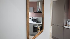 Een moderne keuken met een magnetron, oven en kastjes.