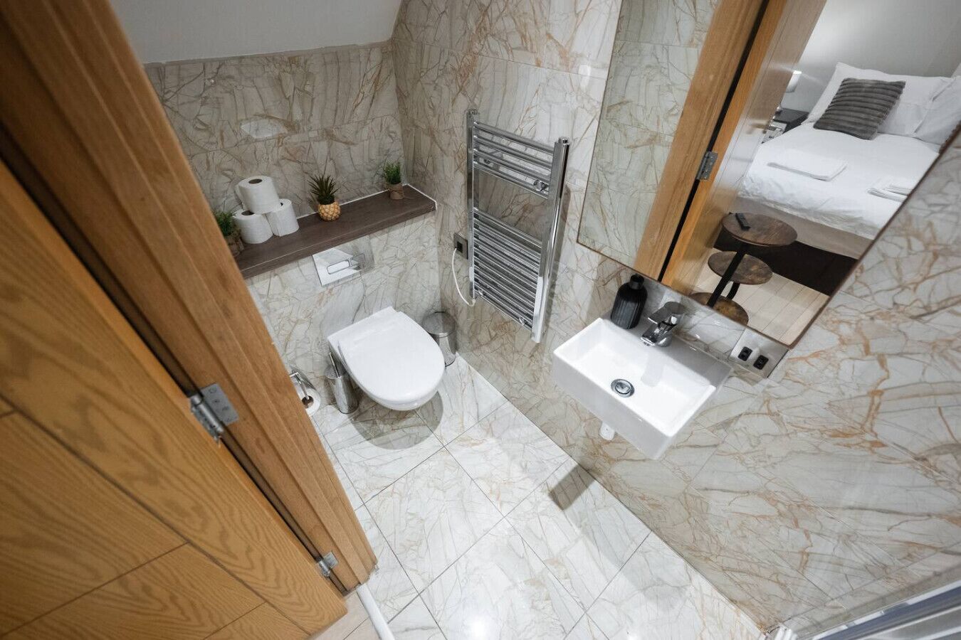 A bathroom with a toilet, sink, and a mirror.