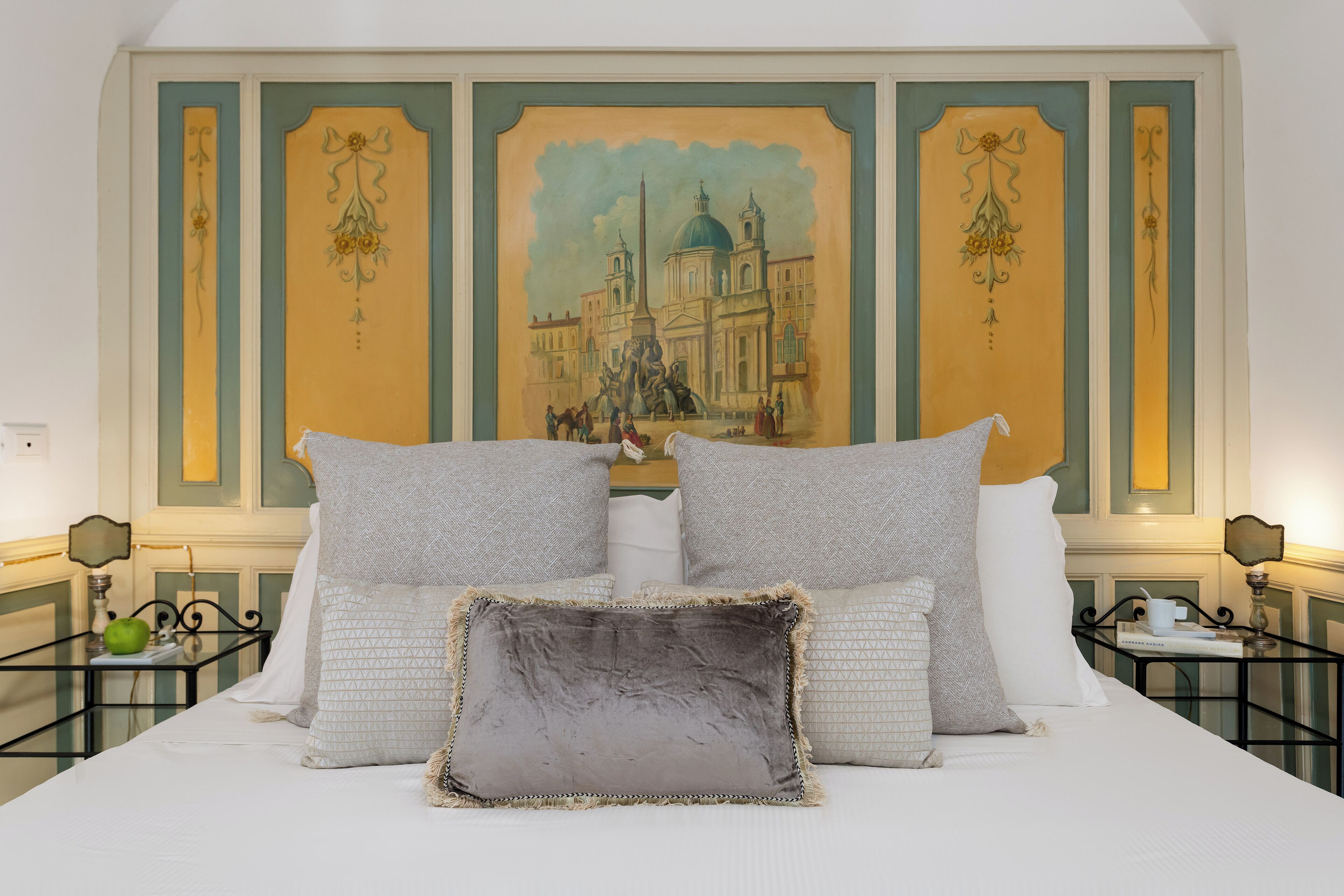 Un lit avec plusieurs oreillers et une tête de lit décorative.