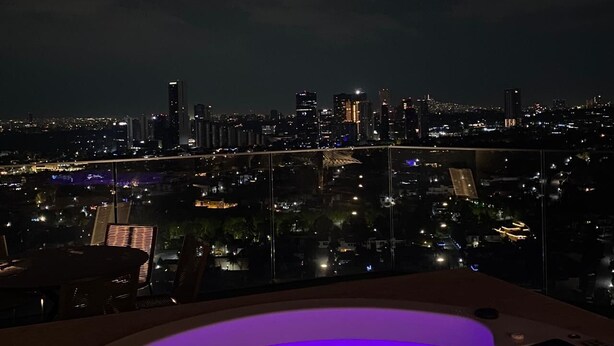 A rooftop terrace with a hot tub and a city view at night. - Exclusive apartment in Andares, the #1 in Guadalajara - Swimming pool - Jacuzzi - AC (Zapopan)
