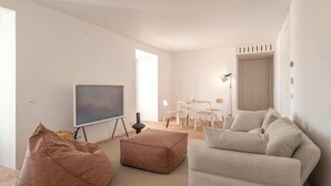 Een moderne woonkamer met een flatscreen televisie, een bank, een salontafel en een relaxstoel.