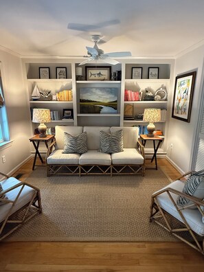 A living room with a sofa set, a coffee table, and a bookshelf.