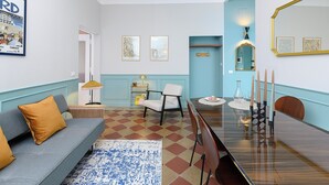 Un salon moderne avec un canapé, des fauteuils, une table à manger et des œuvres d’art accrochées aux murs.